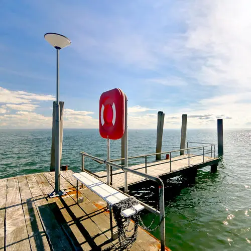 TwooDoo - Anlegesteg im Sonnenschein mit Blick auf die offene See.
